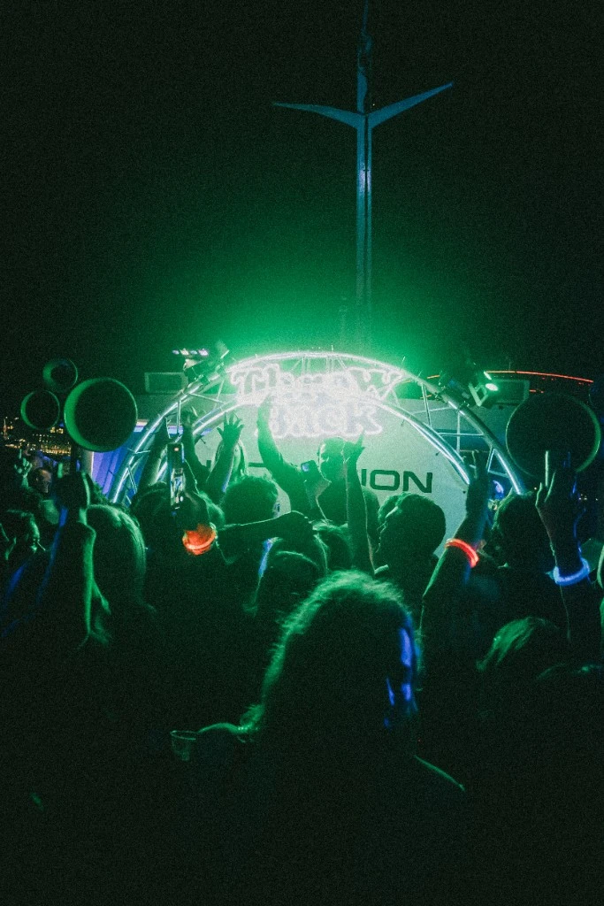 Throwback neon sign glowing green on the harbour at night
